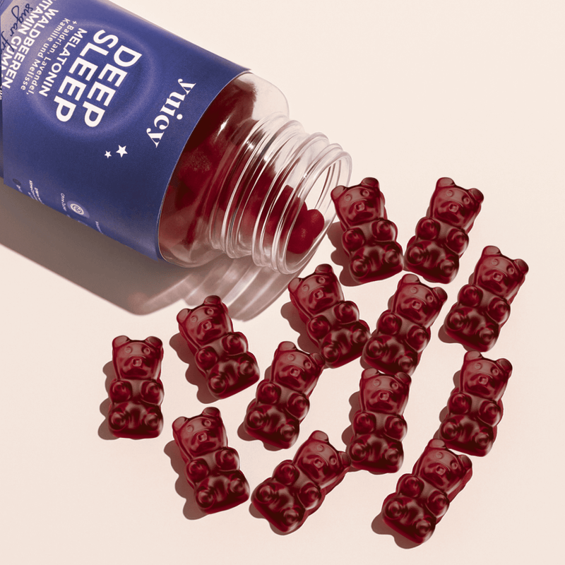 Deep Sleep Dose liegen auf einem hellen Untergrund, mehrere Gummibärchen fallen heraus.